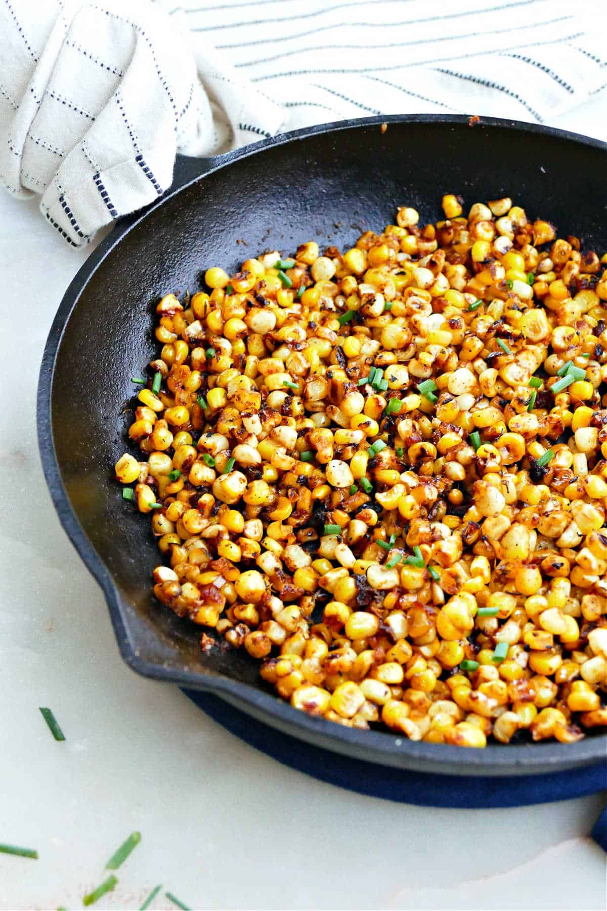 skillet charred corn sitting on a counter with a napkin around the handle