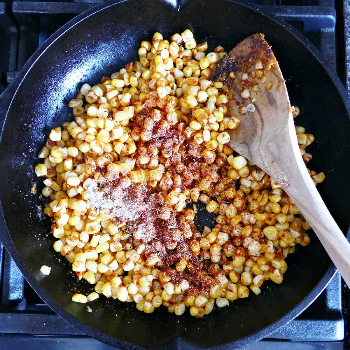 sweet corn with added blackened seasonings cooking in a skillet