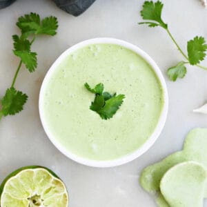 cilantro garlic sauce in a bowl surrounded by ingredients