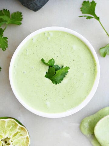 cilantro garlic sauce in a bowl surrounded by ingredients