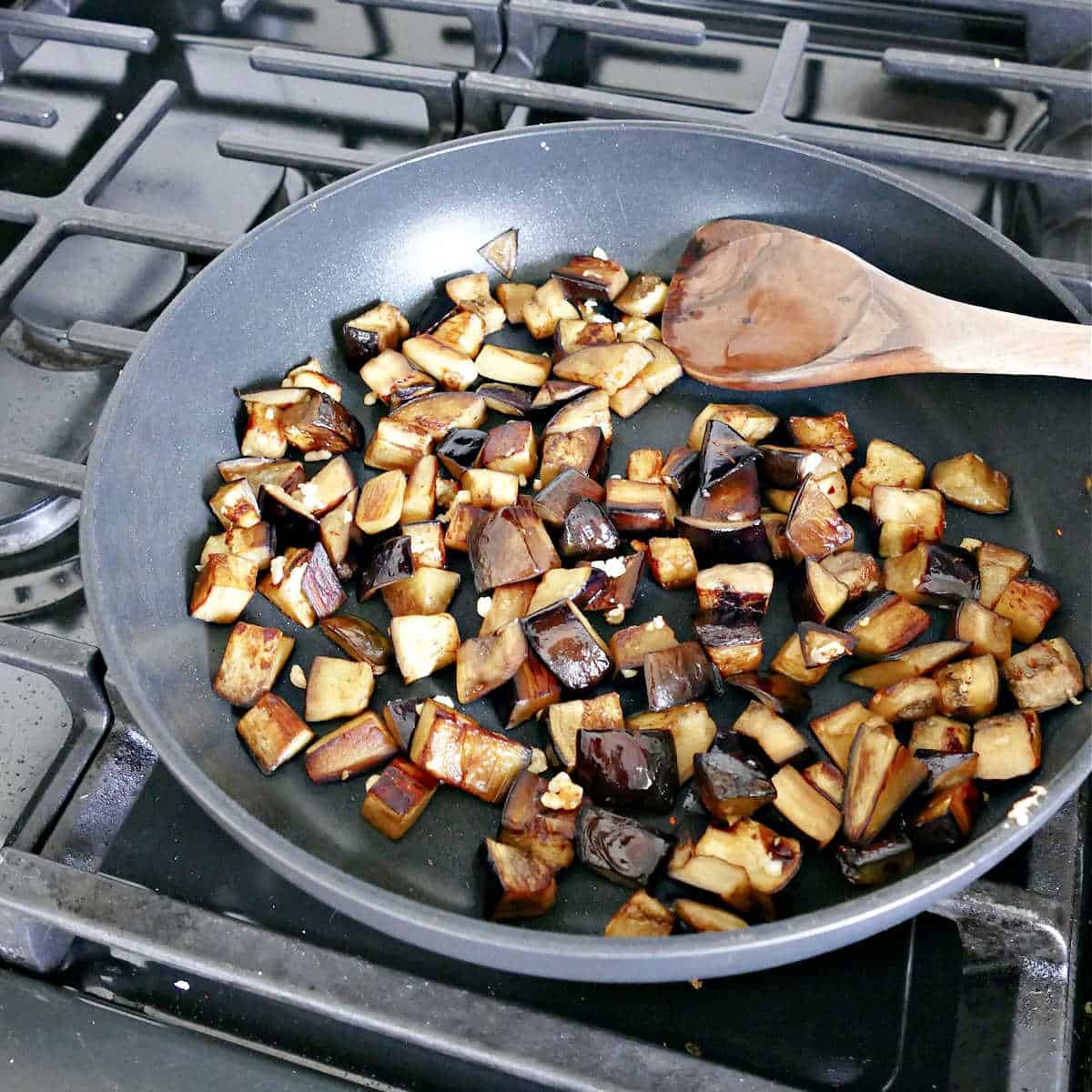 cubed eggplant cooked in olive oil and garlic in a skillet