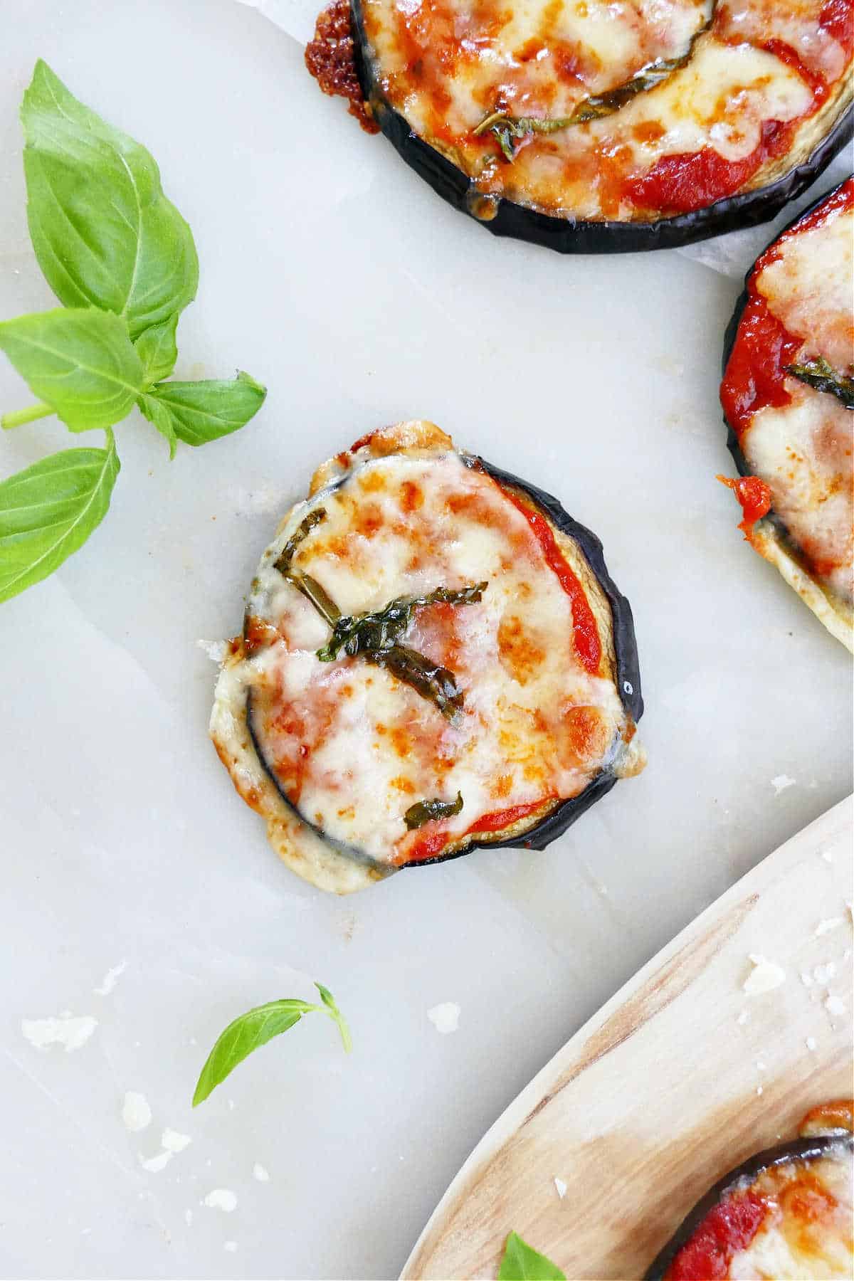 eggplant pizza bite topped with basil on a counter