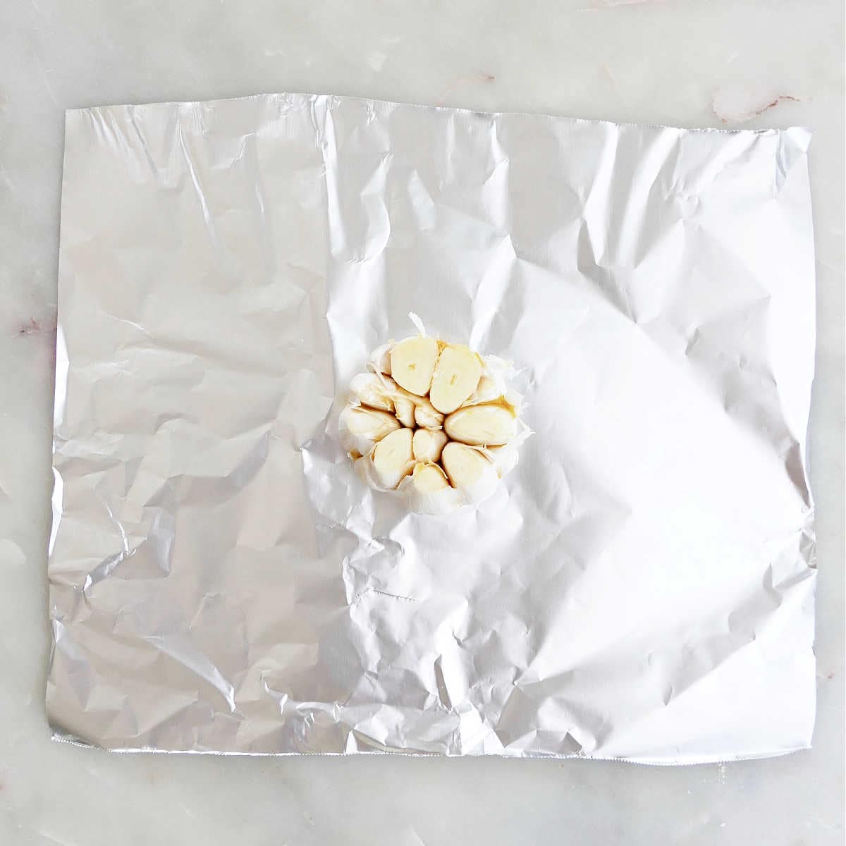head of garlic on a piece of foil drizzled with oil
