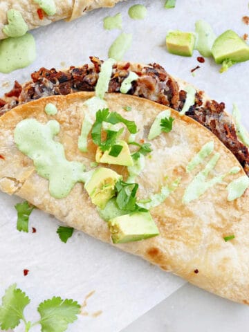 crispy smashed black bean taco with cilantro sauce on a counter