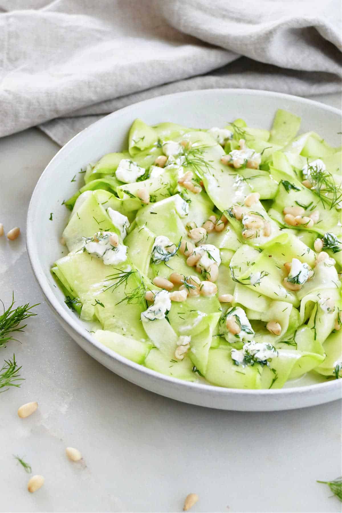 lemon zucchini ribbon salad on a plate next to a napkin