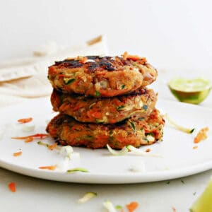 3 zucchini and sweet potato fritters in a stack on a plate