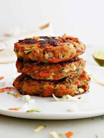 3 zucchini and sweet potato fritters in a stack on a plate