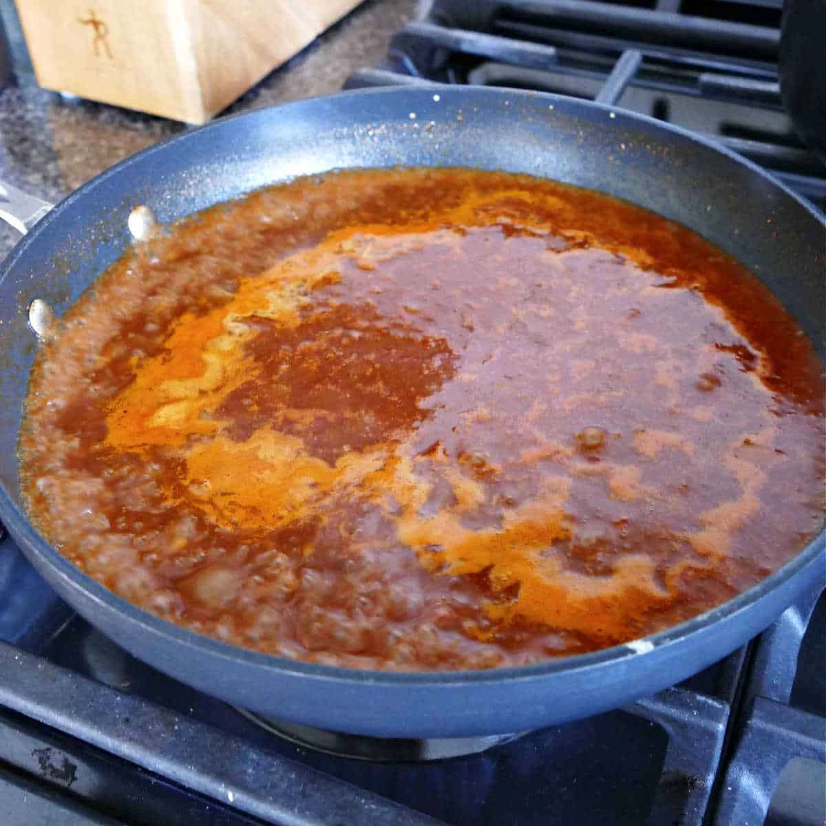 enchilada sauce simmering in a skillet on a stove