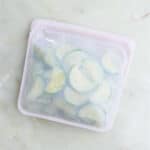 blanched zucchini slices in a silicone bag on a counter before being frozen