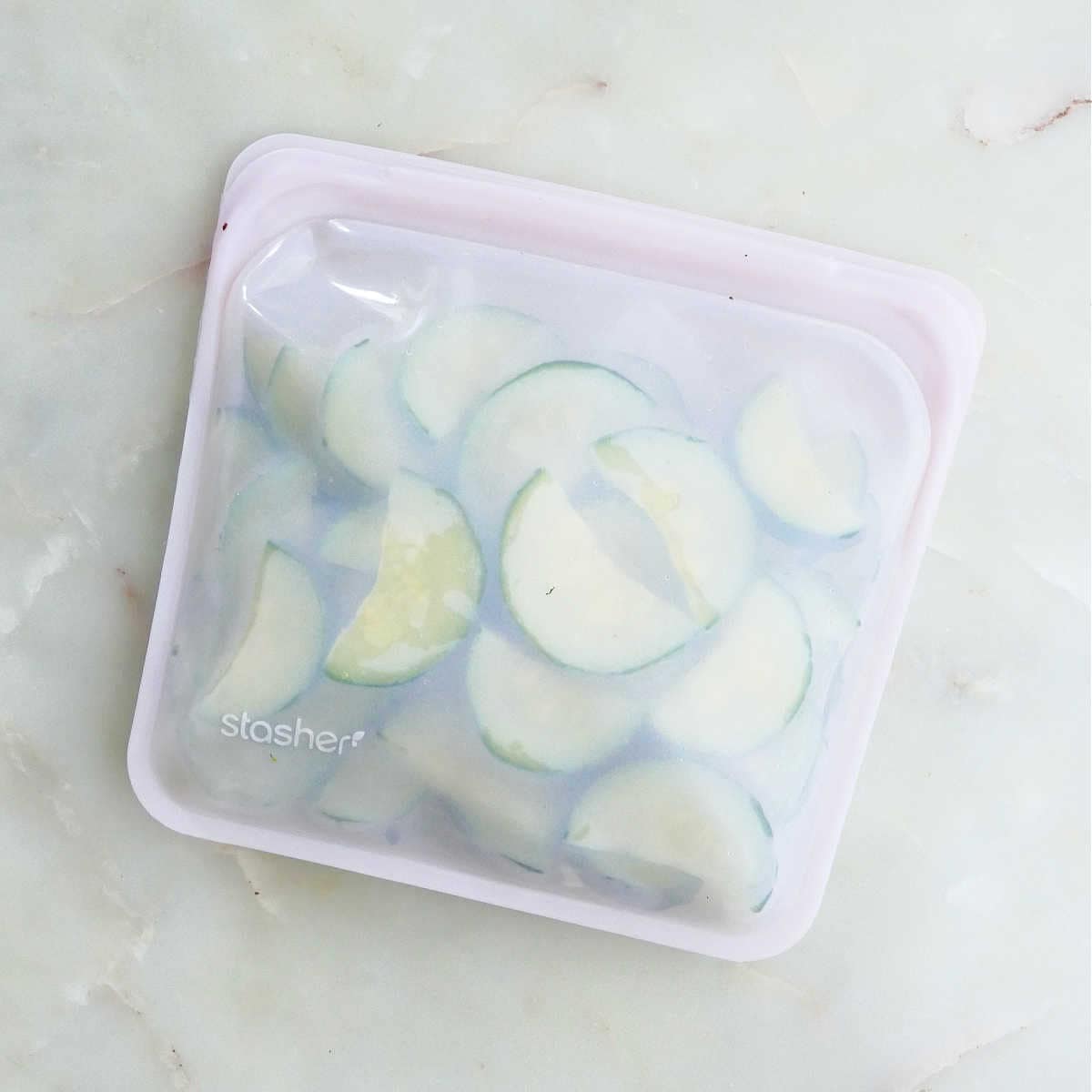 blanched zucchini slices in a silicone bag on a counter before being frozen