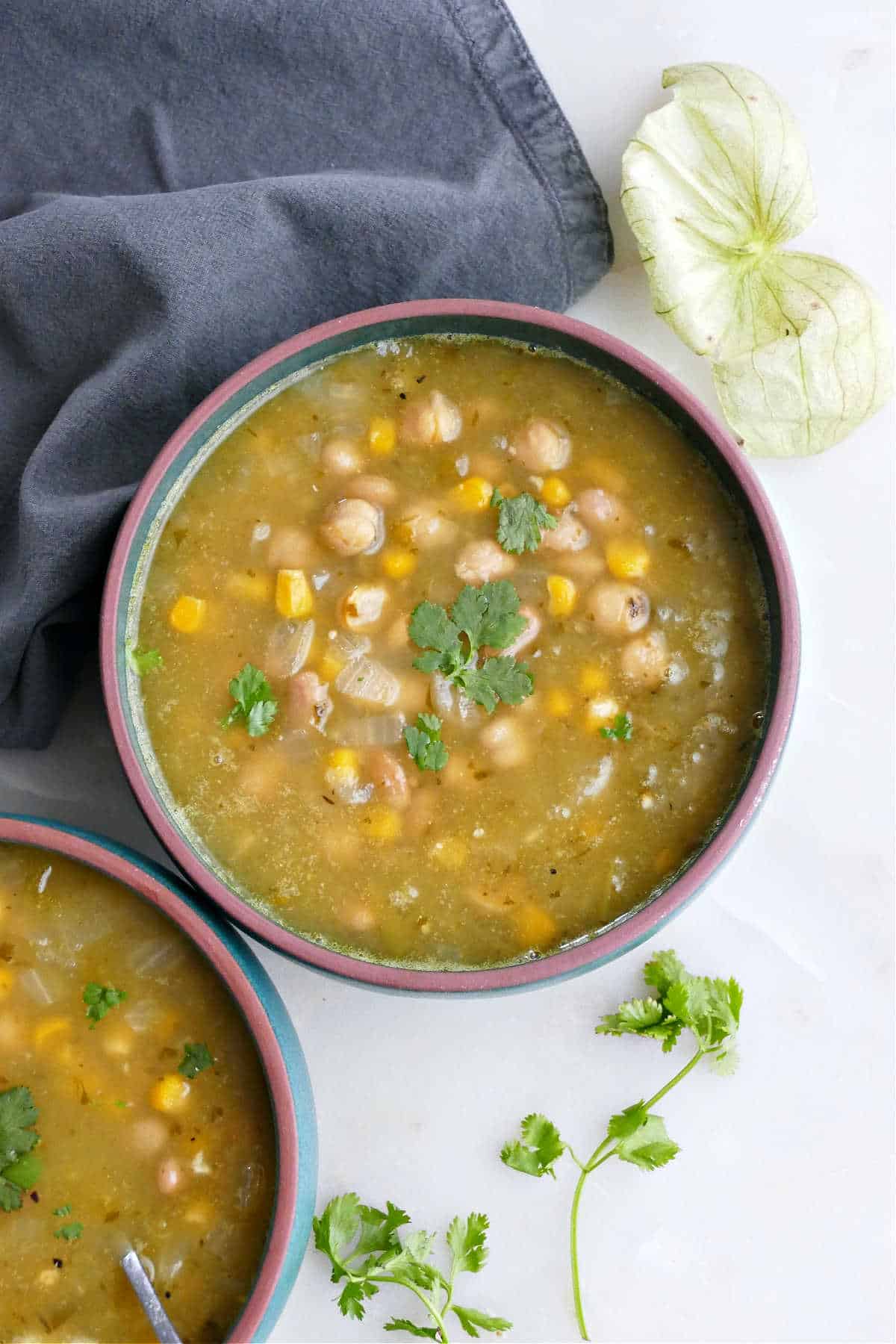 bowl of tomatillo soup with beans topped with cilantro on a counter