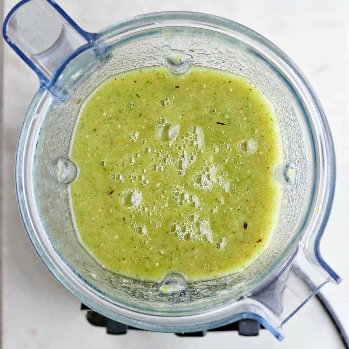 blended tomatillos, jalapeño, and poblano peppers in a Vitamix blender on a counter