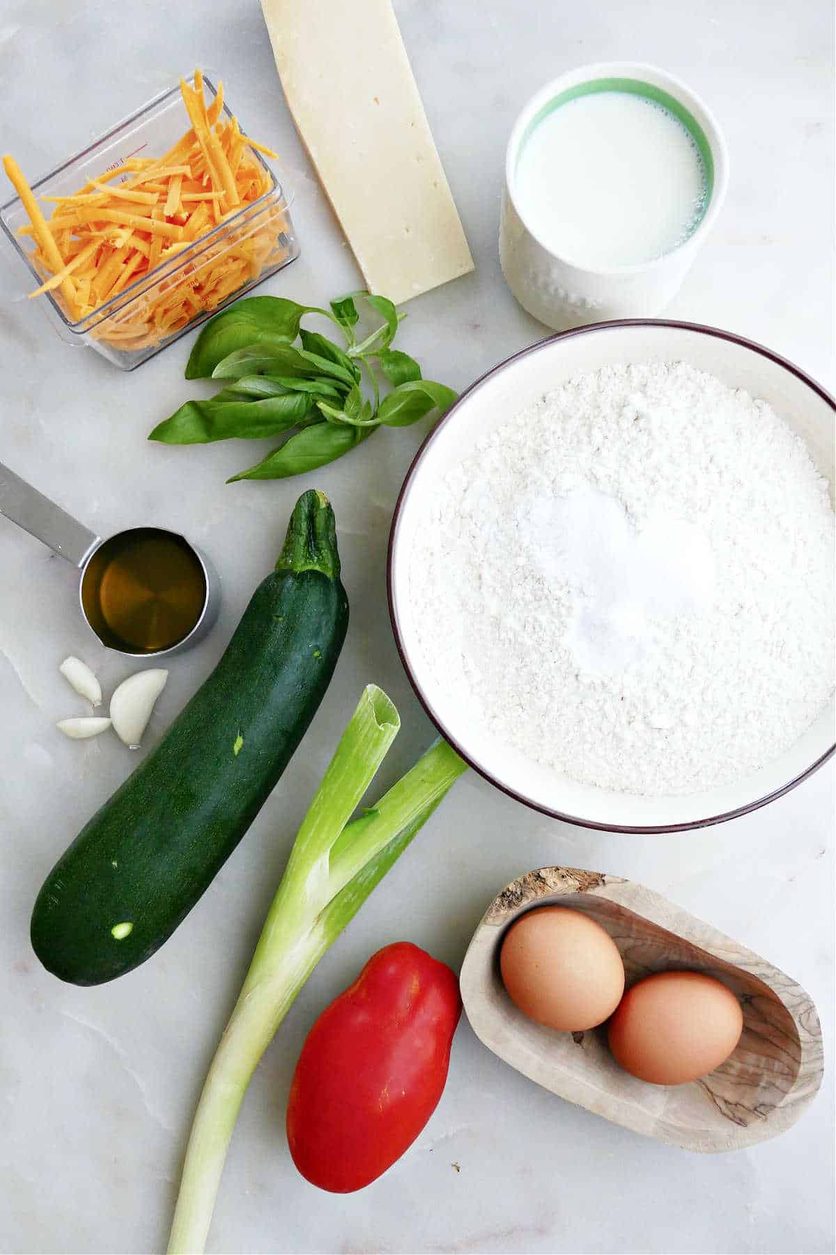cheese, milk, basil, flour, eggs, tomato, green onion, zucchini, garlic, and olive oil