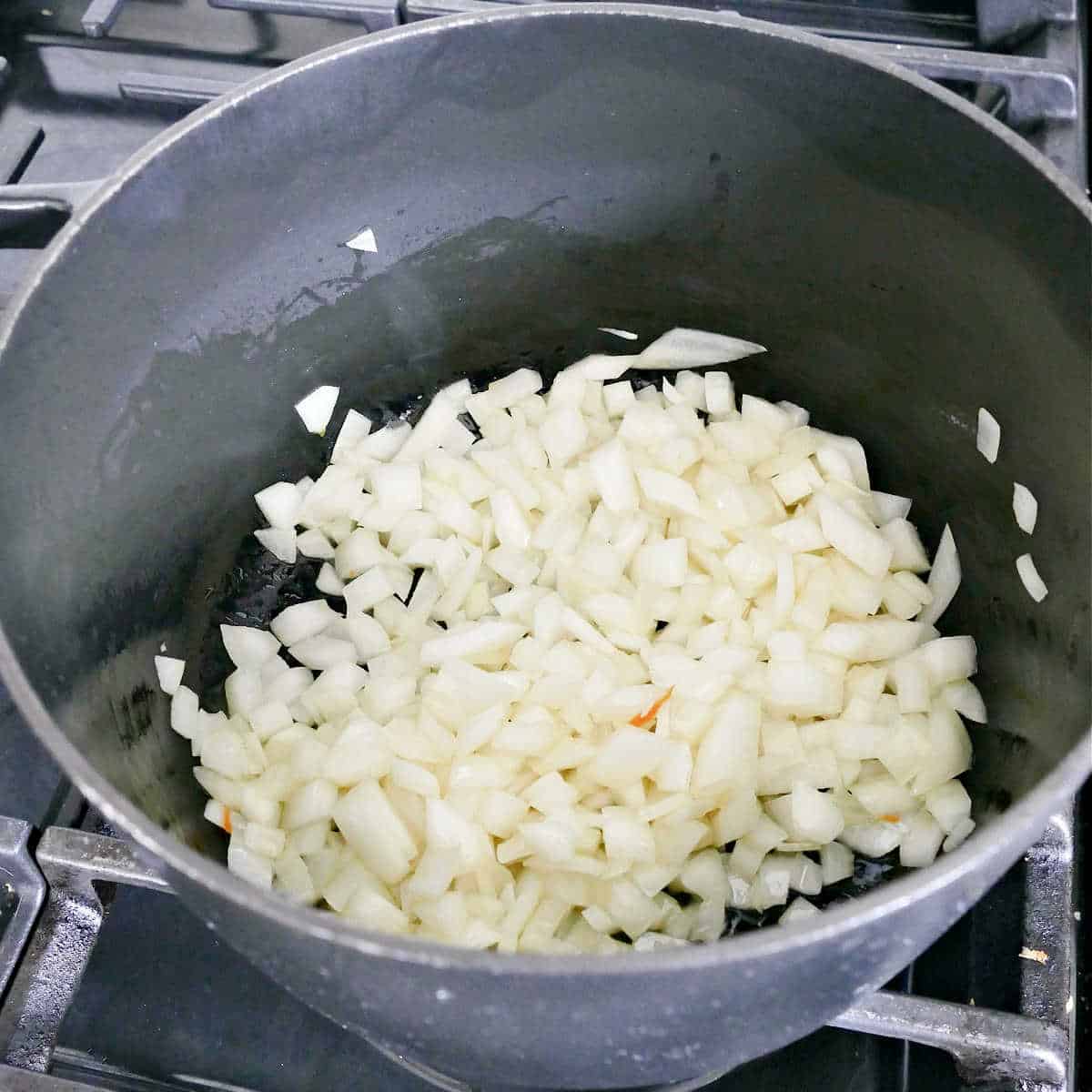 onions cooking in olive oil in a large soup pot on a stove