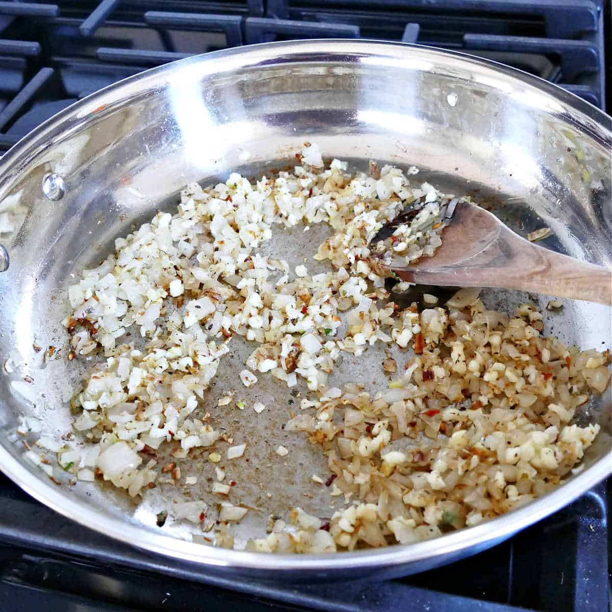 shallots, garlic, and spices cooking in olive oil in a skillet
