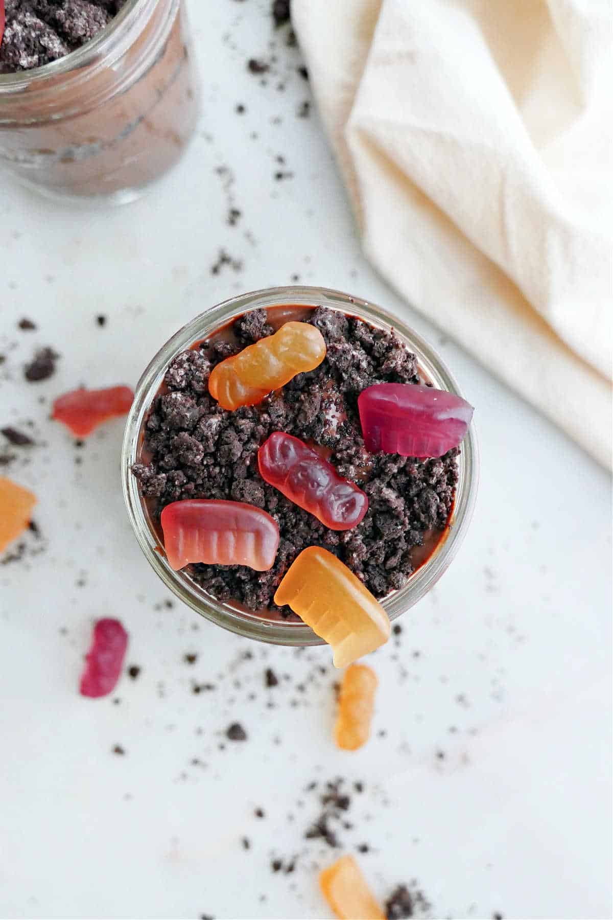 healthy dirt cup with gummy candies and Oreo crumbs in a glass jar