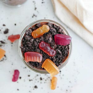 healthy dirt cup with gummy candies and Oreo crumbs in a glass jar