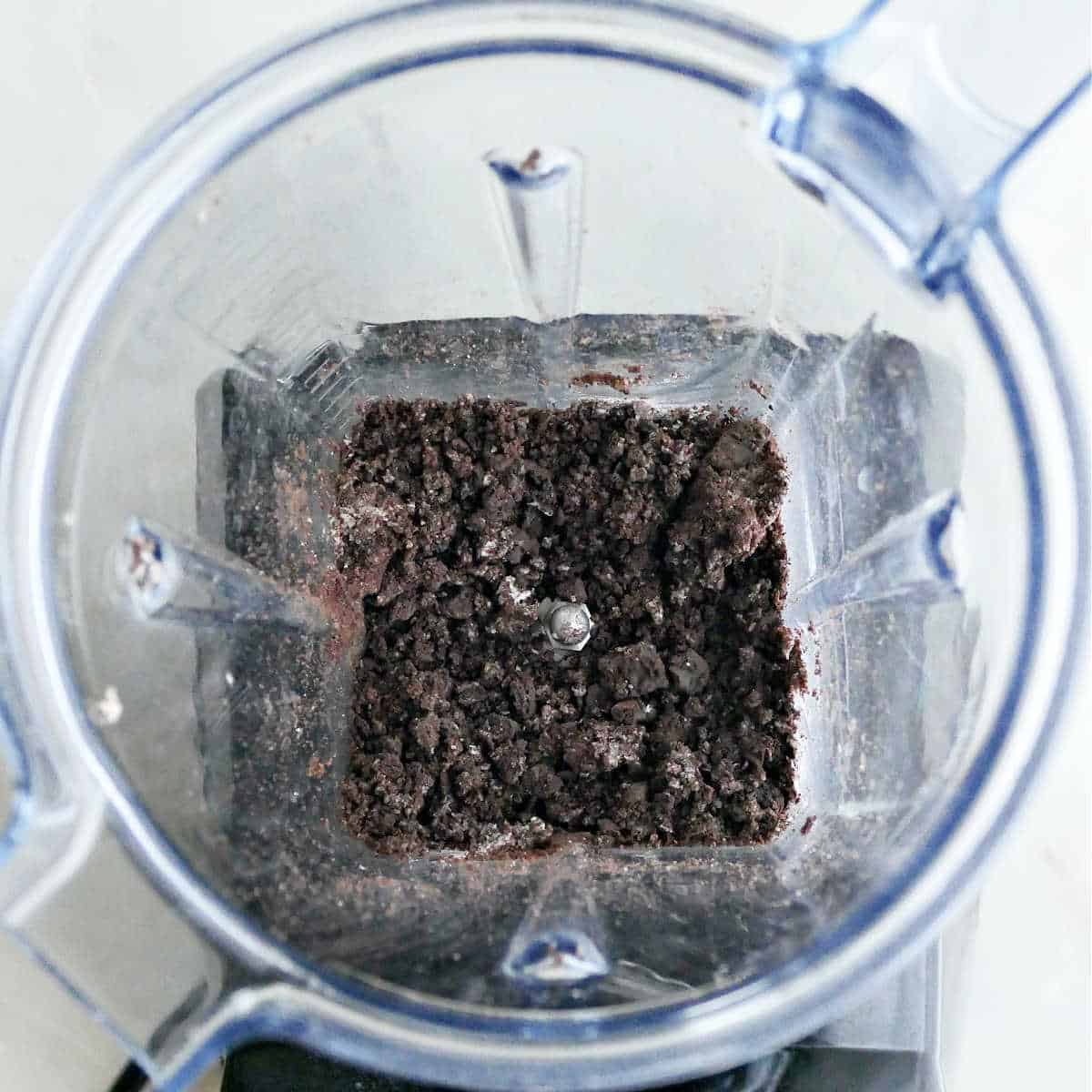 Oreo crumbs in a blender on a counter