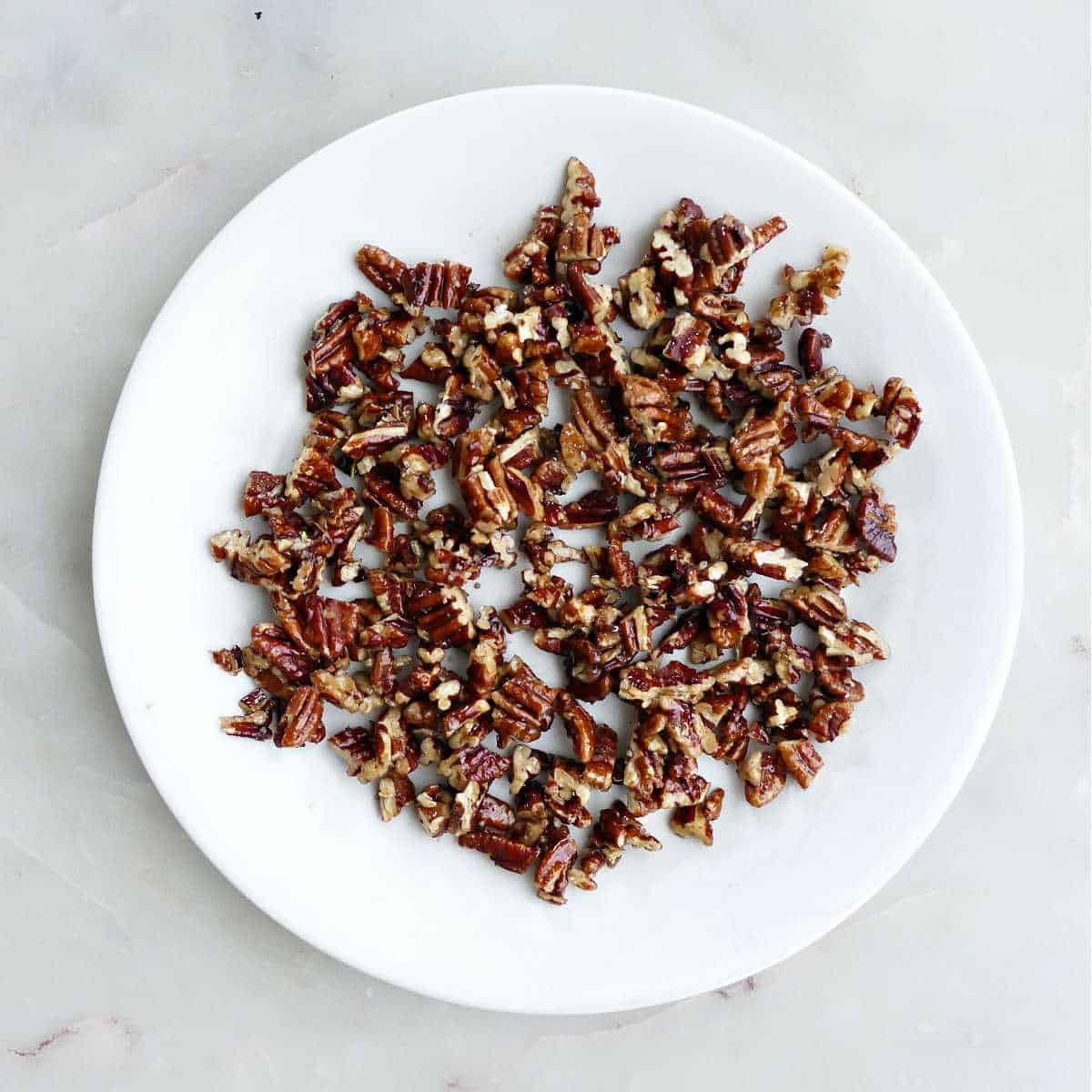 stovetop candied pecans cooling on a plate on a counter