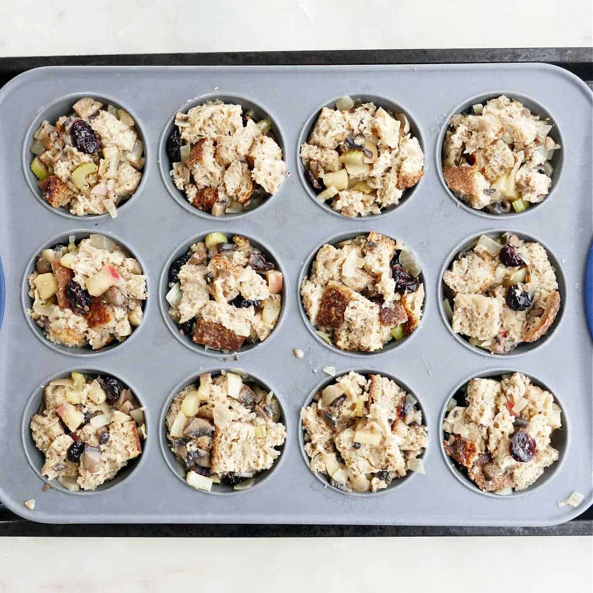 vegetarian stuffing cups in a muffin tray before being baking in the oven