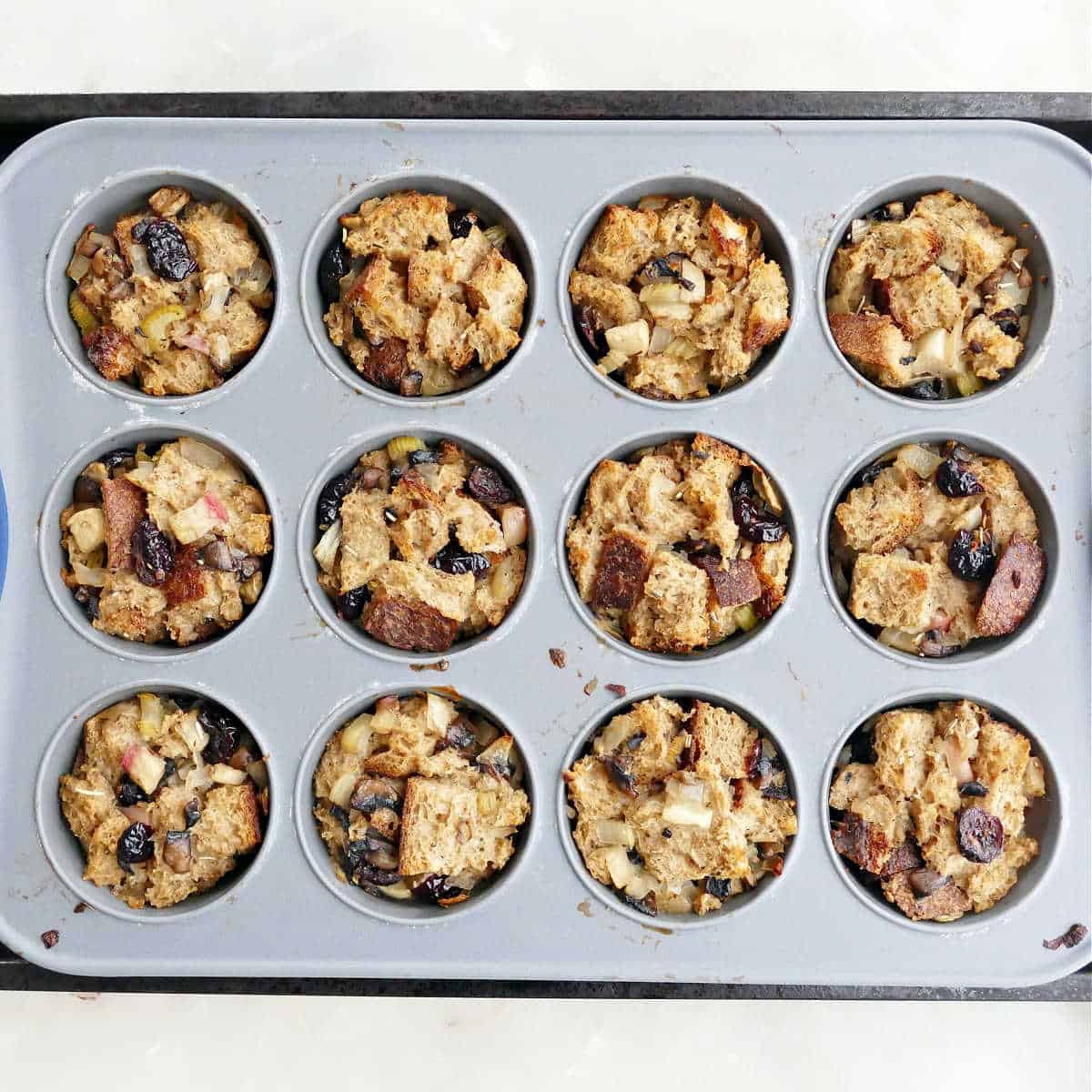 stuffing muffins in a muffin tray after cooking in the oven