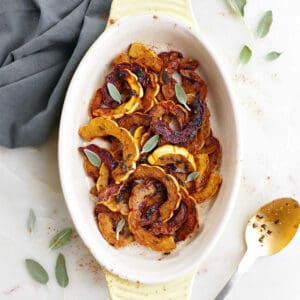 sautéed delicata squash in an oval serving tray topped with sage