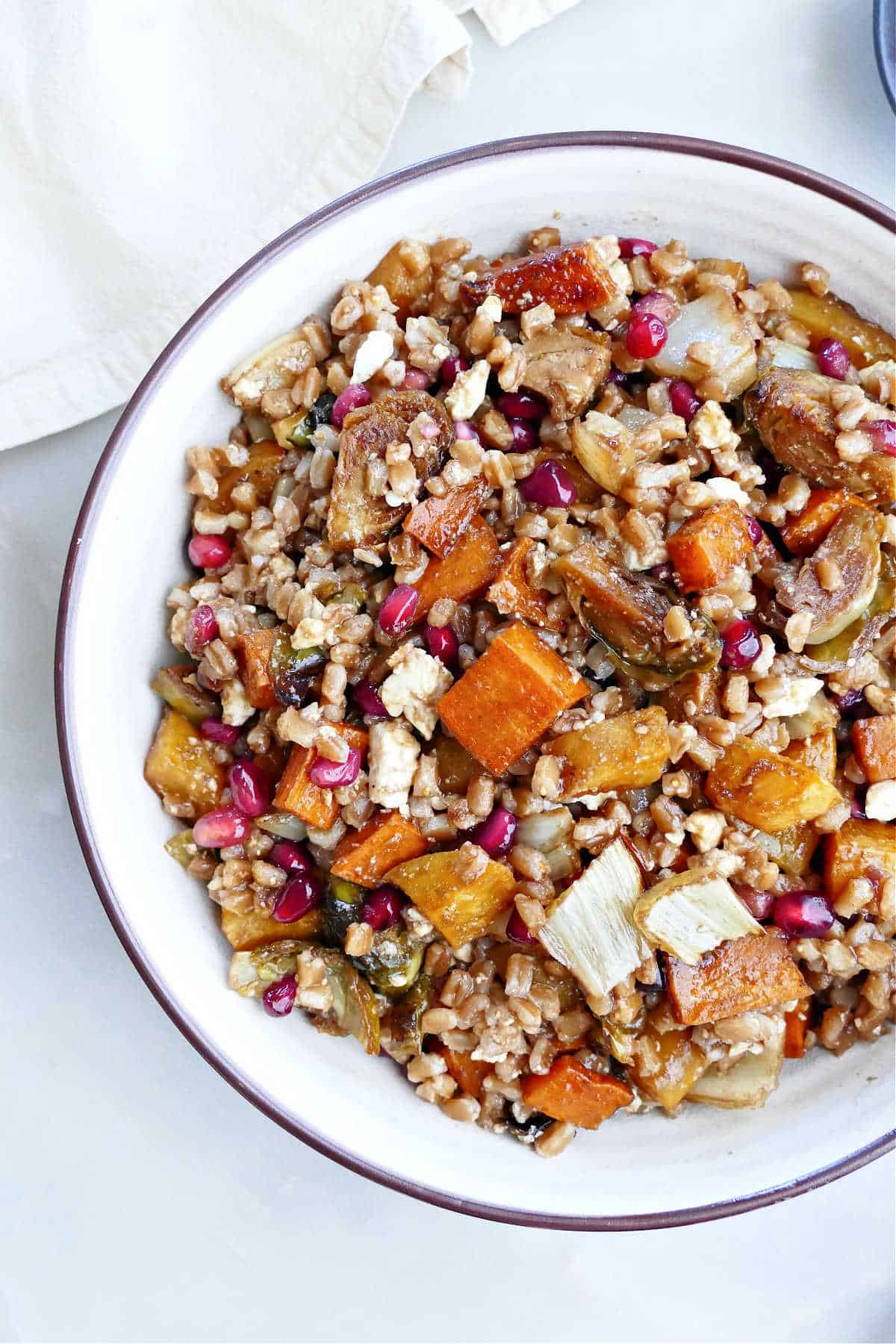 farro, roasted vegetables, pomegranates, and feta with maple balsamic in a bowl