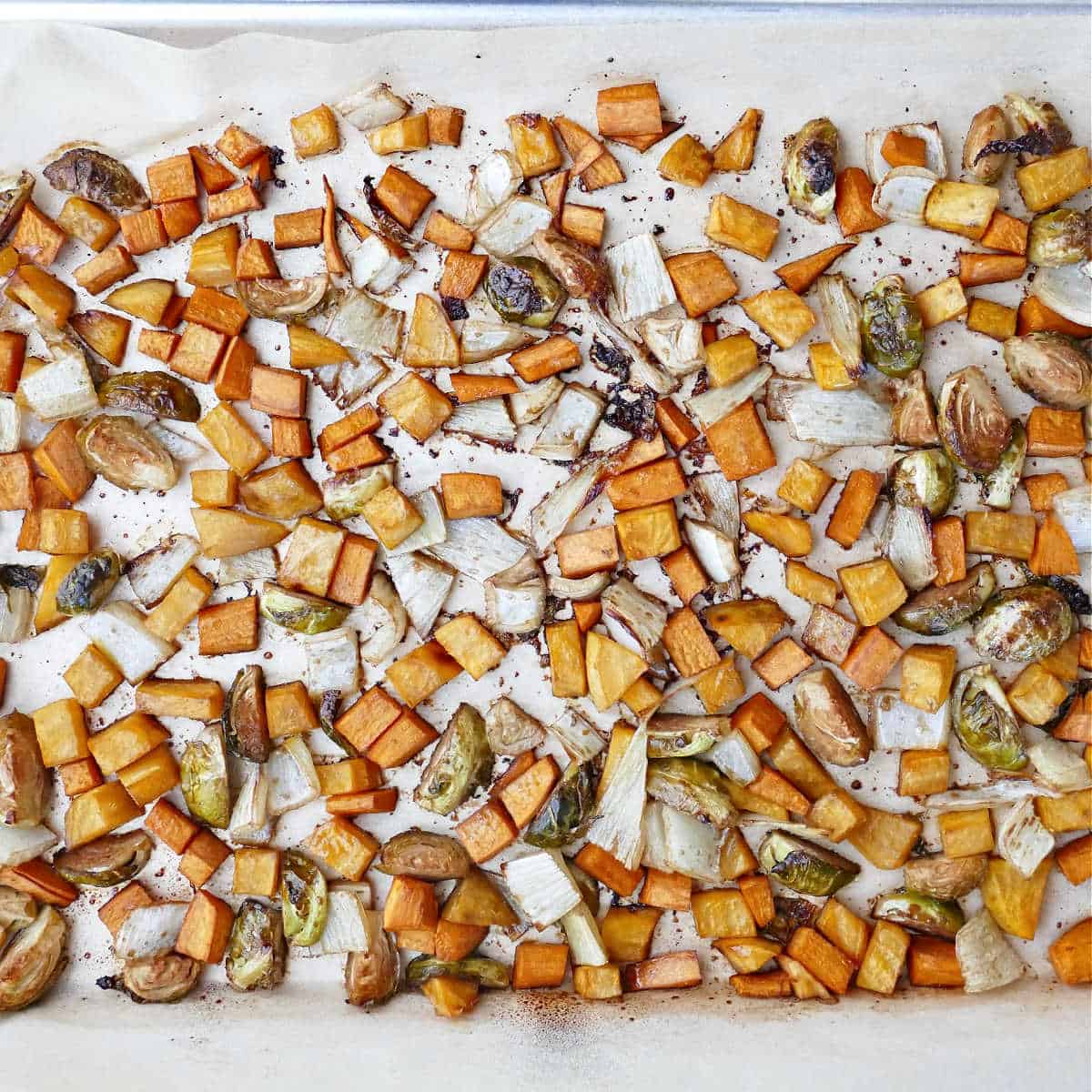roasted winter vegetables with maple balsamic on a sheet pan lined with parchment