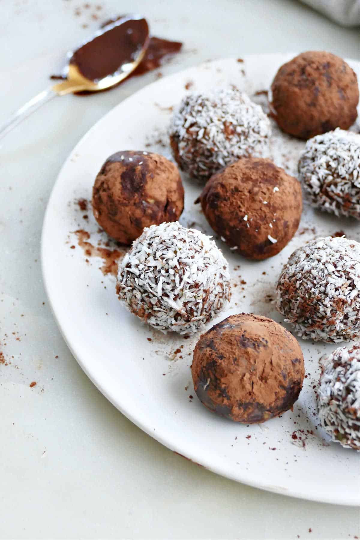 avocado chocolate truffles with cocoa powder and shredded coconut on a plate