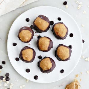 7 vegan buckeye balls on a plate with chocolate chips