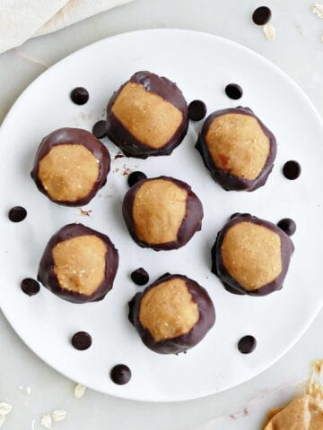 7 vegan buckeye balls on a plate with chocolate chips