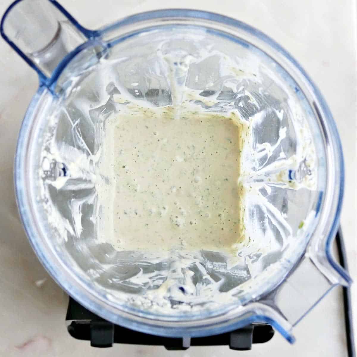 mint tahini sauce after being blended in a high-powered blender on a counter