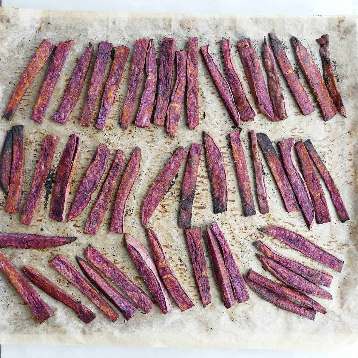 baked purple sweet potato fries after coming out of the oven on a baking sheet