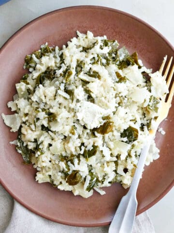 baked collard greens and rice on a serving plate with a fork