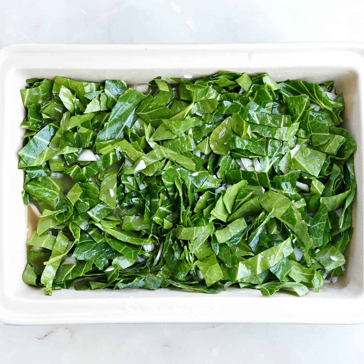 ingredients for collard green rice in a rectangular baking dish before going into the oven