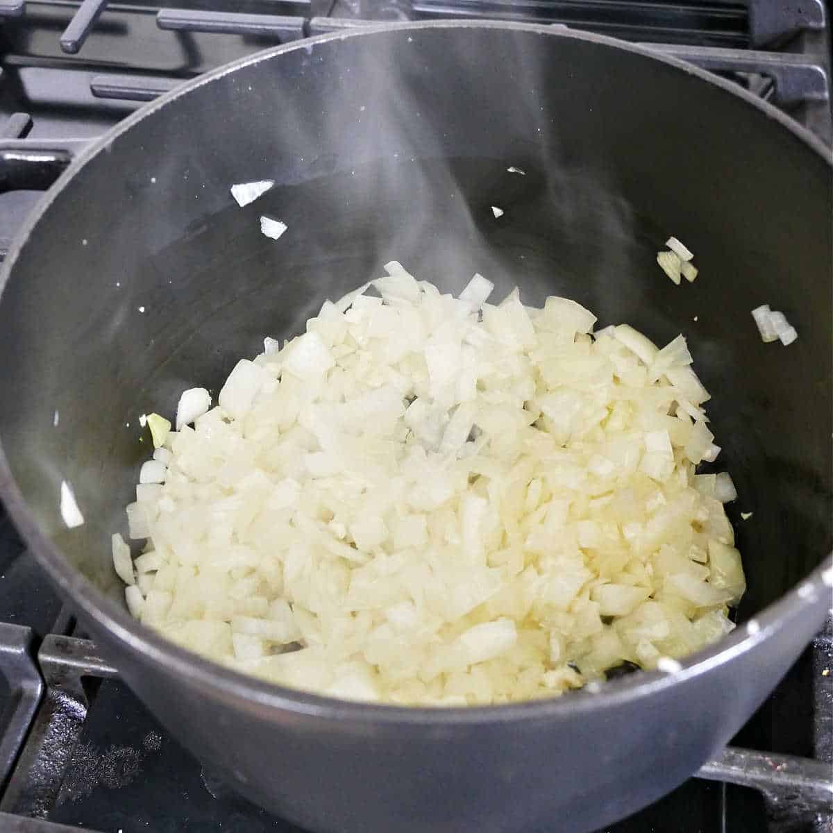 onion and garlic cooking in olive oil in a large soup pot on a stove