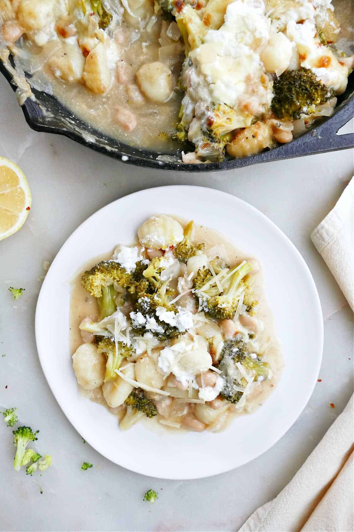 broccoli, gnocchi, and cheese casserole on a plate next to skillet
