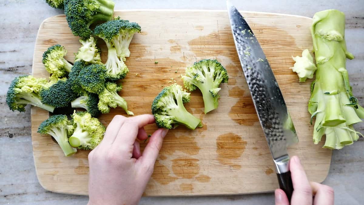 broccoli floret cut in half lengthwise on a cutting board next to a knife