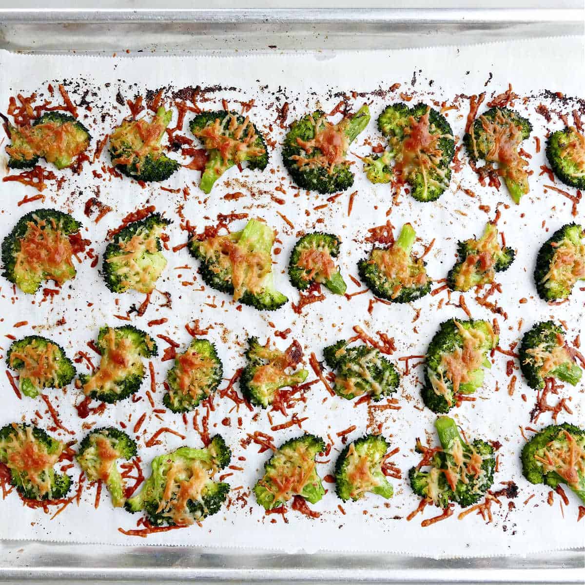 crispy broccoli chips with cheese on a baking sheet after being baked