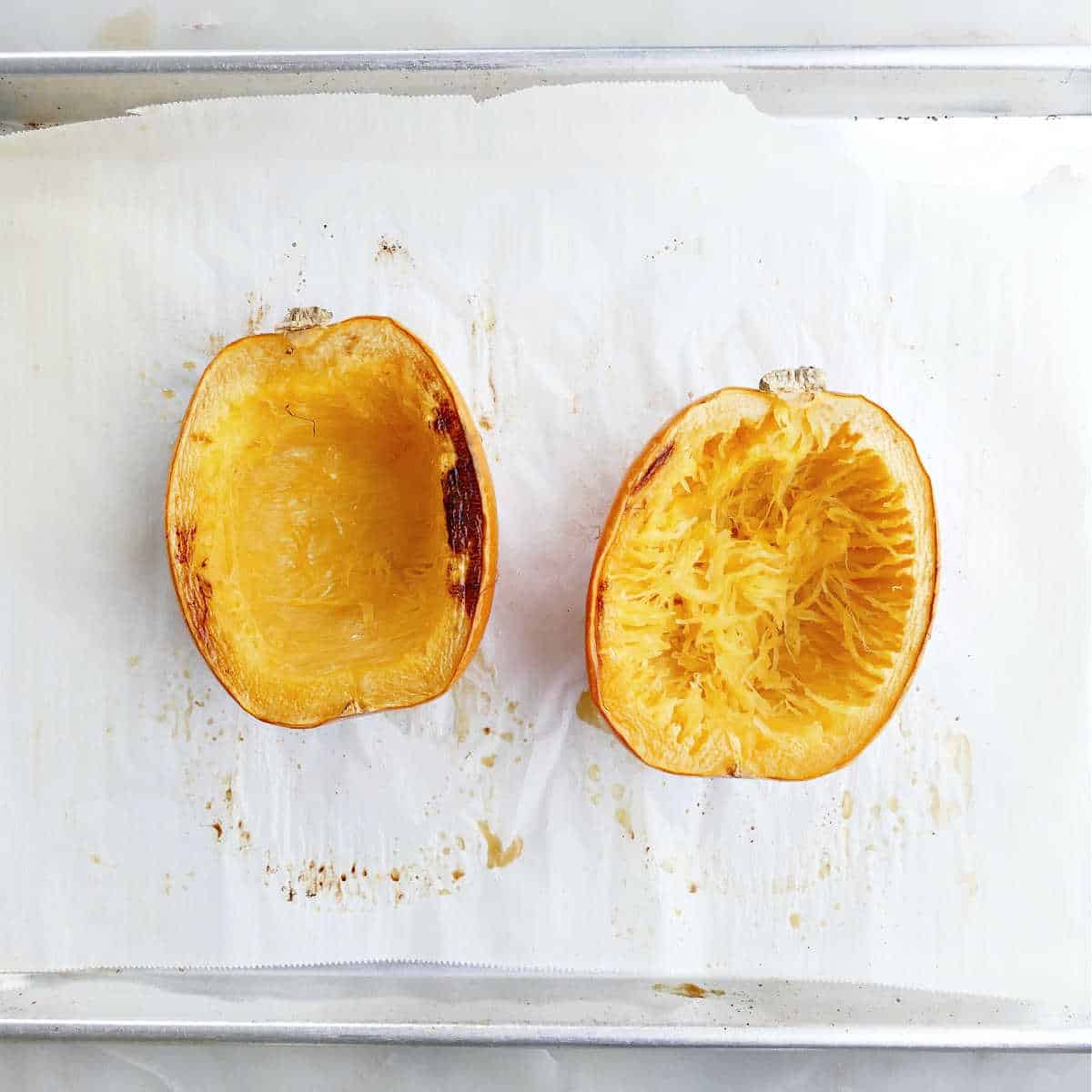 spaghetti squash halves cut side up on a baking sheet after roasting