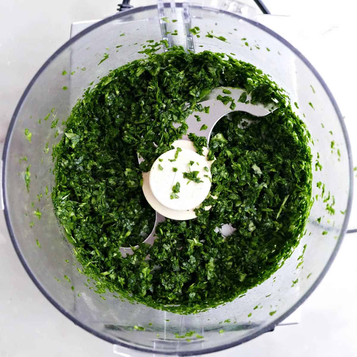 Finely chopped spinach in a food processor.