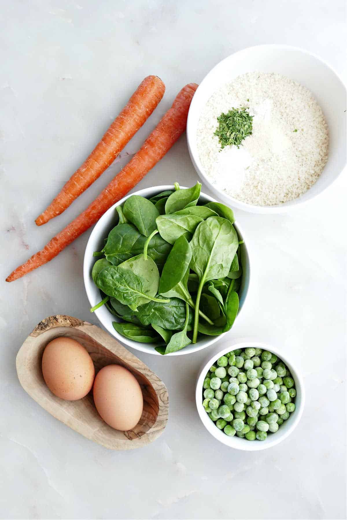 Ingredients needed to make veggie tots from scratch in individual bowls.