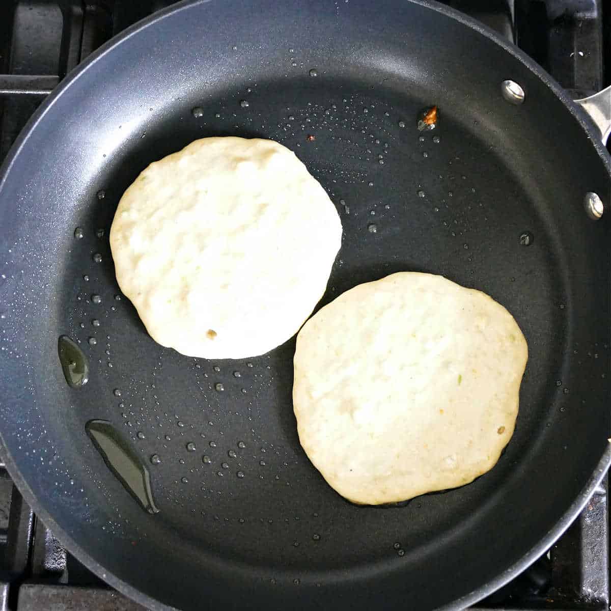 Cooking the avocado pancakes in a large skillet.