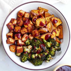 Bbq marinated tofu topped with sauce on a plate with broccoli.
