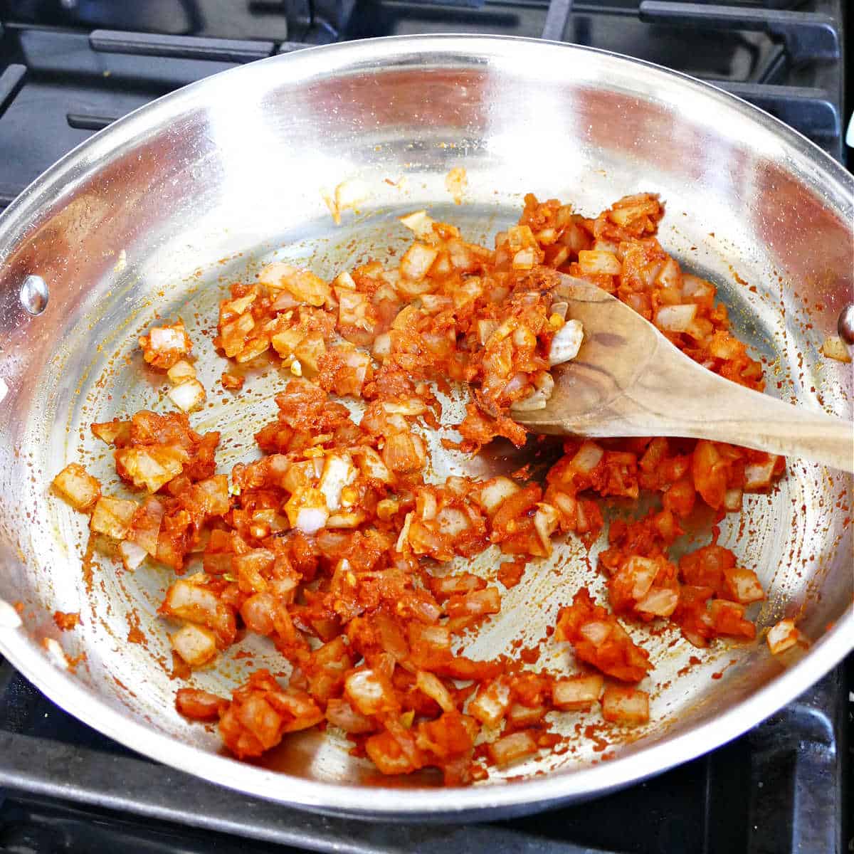 Cooking the onions for coconut milk tofu in a large pan.