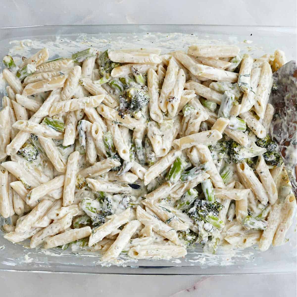 Asparagus broccoli pasta with penne noodles in a large casserole dish.