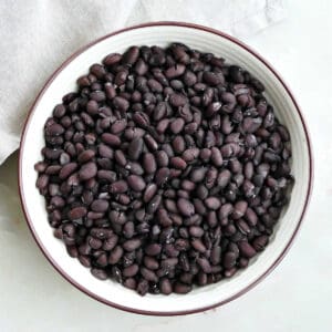 Black beans in a large serving bowl after being cooked on the stovetop.
