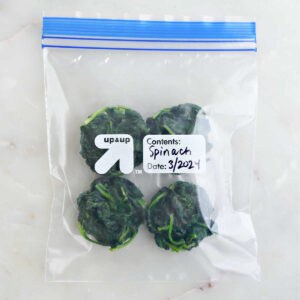 Frozen spinach in a labeled freezer bag.