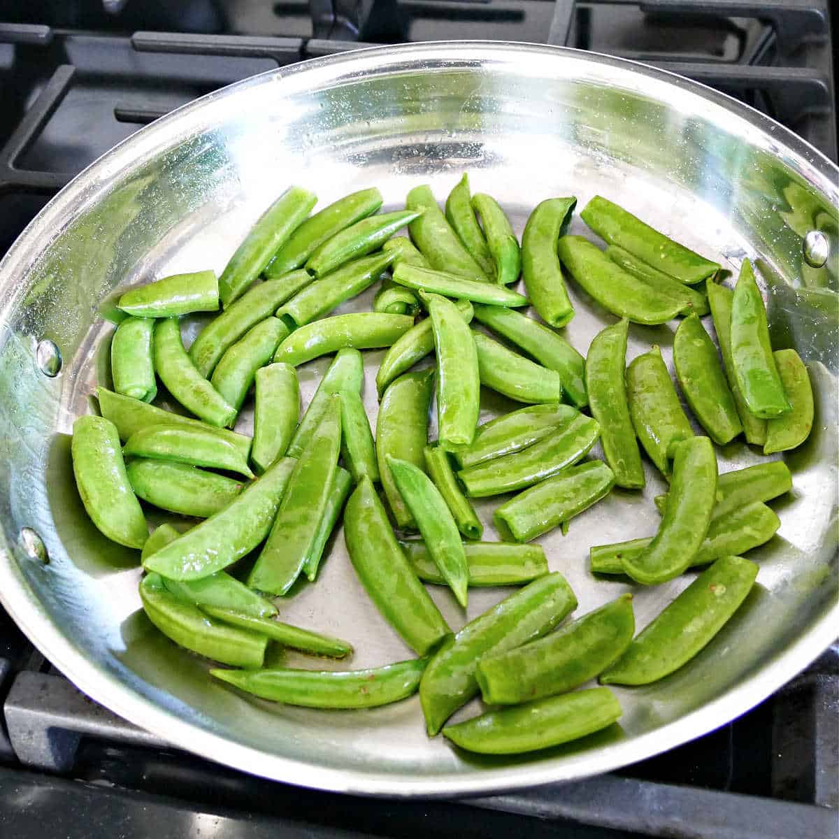 Snap peas in a large stainless steel skillet.