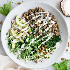 A large lentil bowl bowl packed with veggies topped with homemade dressing.